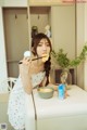 A woman sitting at a kitchen counter eating a piece of food.