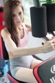 A woman sitting on a bench in a gym.