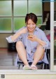 A woman sitting on a chair looking at her phone.