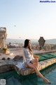 A woman sitting on the edge of a swimming pool.