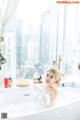 A woman sitting in a bathtub with a plate of food.