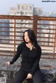 A woman sitting on top of a metal railing.