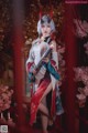 A woman dressed in a kimono holding a sword in front of flowers.