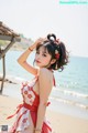 A woman in a red and white dress on the beach.