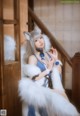 A woman in a blue and white outfit sitting on a staircase.