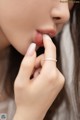 A close up of a woman with a ring on her finger.