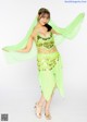 A woman in a green belly dance outfit posing for a picture.