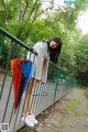 A woman standing on a bridge holding an umbrella.