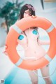 A woman in a bikini holding a life preserver.