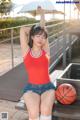 A woman sitting on a bench with a basketball.